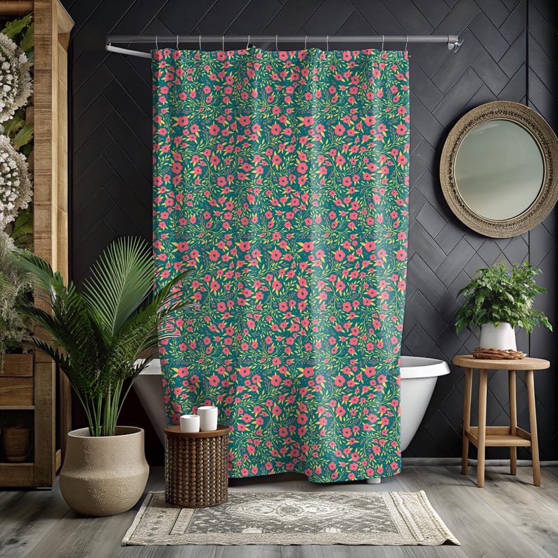 May include: A teal shower curtain with a repeating floral pattern of pink flowers and green leaves. The curtain is hanging in a bathroom with a white bathtub, a round mirror, and a potted plant. The overall theme is floral and botanical.
