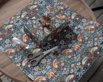 Könnte beinhalten: Eine blaue und grüne Geschenkpapier mit einem braunen Band und einer Schachtel darauf. Das Muster zeigt Vögel, Blumen und Blätter.