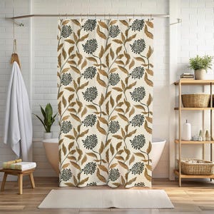 May include: A beige shower curtain with a repeating pattern of brown leaves and black, dotted flower clusters. The curtain hangs in front of a white bathtub, with a wooden shelf and a small stool visible in the background.