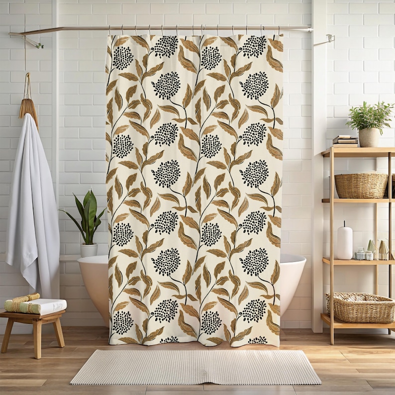 May include: A beige shower curtain with a repeating pattern of brown leaves and black, dotted flower clusters. The curtain hangs in front of a white bathtub, with a wooden shelf and a small stool visible in the background.