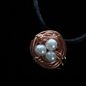Copper wire nest with 3 white eggs