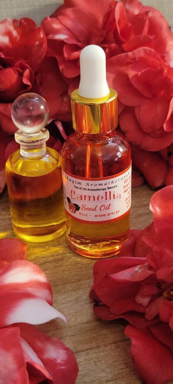 Bouteilles D'huile De Camélia Et Fleurs De Camélia Sur Une Table