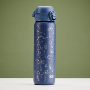 Puede incluir: Una botella de agua azul marino con tapa abatible. La botella está decorada con un patrón plateado de dinosaurios y palmeras, con las palabras "INDIE" y "ION" impresas en la botella.