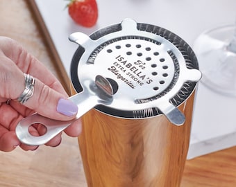 May include: A stainless steel cocktail strainer with a handle. The strainer has a circular mesh and a personalised inscription that reads "For Isabella's Extra Strong Margaritas".