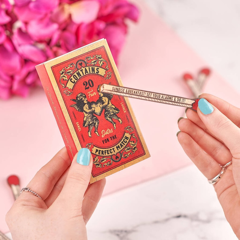 A hand holding a red box and a paper match