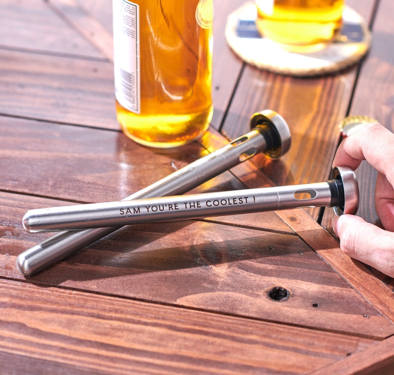 Pode incluir: Dois tamp&otilde;es de garrafa prateados com uma inscri&ccedil;&atilde;o personalizada que diz "Sam, voc&ecirc; &eacute; o mais legal!"