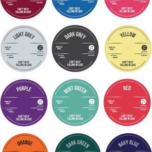 Twelve personalised vinyl record label colour options arranged in a grid, including cranberry, blue, pink, light grey, dark grey, yellow, purple, mint green, red, orange, dark green and navy blue.
