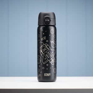 Könnte beinhalten: Schwarze, isolierte Wasserflasche mit Klappdeckel. Die Flasche zeigt eine weiße Illustration eines Raumschiffs, Sterne und Planeten. Der Name "ALFIE" und das Jahr "2019" sind auf der Rakete aufgedruckt. Der Markenname "ION8" ist unten aufgedruckt.