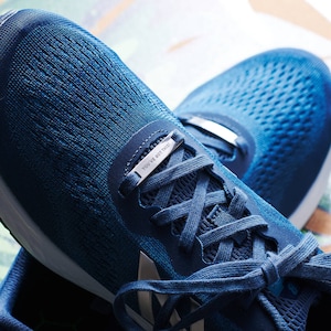 K&ouml;nnte beinhalten: Blaue Laufschuhe mit einem silbernen Schnallenanh&auml;nger mit der Aufschrift "You've got this".