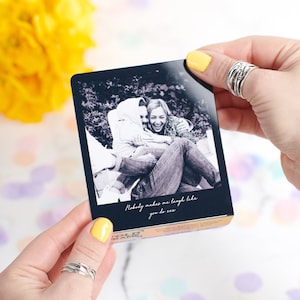 May include: A black and white photograph of two people laughing. The photo is printed on a card with the text "Nobody makes me laugh like you do" printed below the photo.