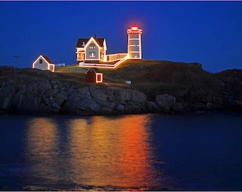May include: A white lighthouse with a red roof and a small white house next to it, both illuminated with Christmas lights, on a rocky island at night.