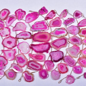 May include: A strand of pink agate gemstone beads, each bead is a unique slice of agate with a natural, irregular shape. The beads are strung on thin wire and are ready for jewellery making.