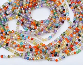May include: A strand of colorful faceted gemstone beads. The beads are small and round, and they are strung on a clear thread. The beads are a variety of colors, including red, orange, yellow, green, blue, purple, and pink.