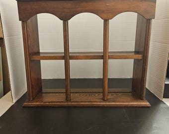Puede incluir: Estantería de pared de madera marrón oscuro con tres aberturas arqueadas y dos estantes. La estantería está diseñada para montaje en pared y es adecuada para exhibir objetos pequeños.