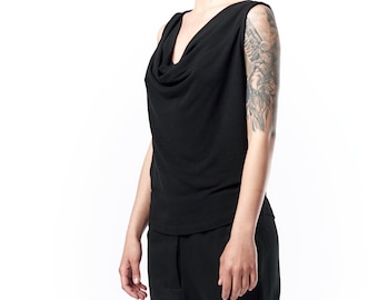 May include: Black sleeveless top with a cowl neck and matching black joggers. The top has a draped neckline, and the joggers have a relaxed fit with elastic cuffs. The outfit is made of a soft, comfortable material.