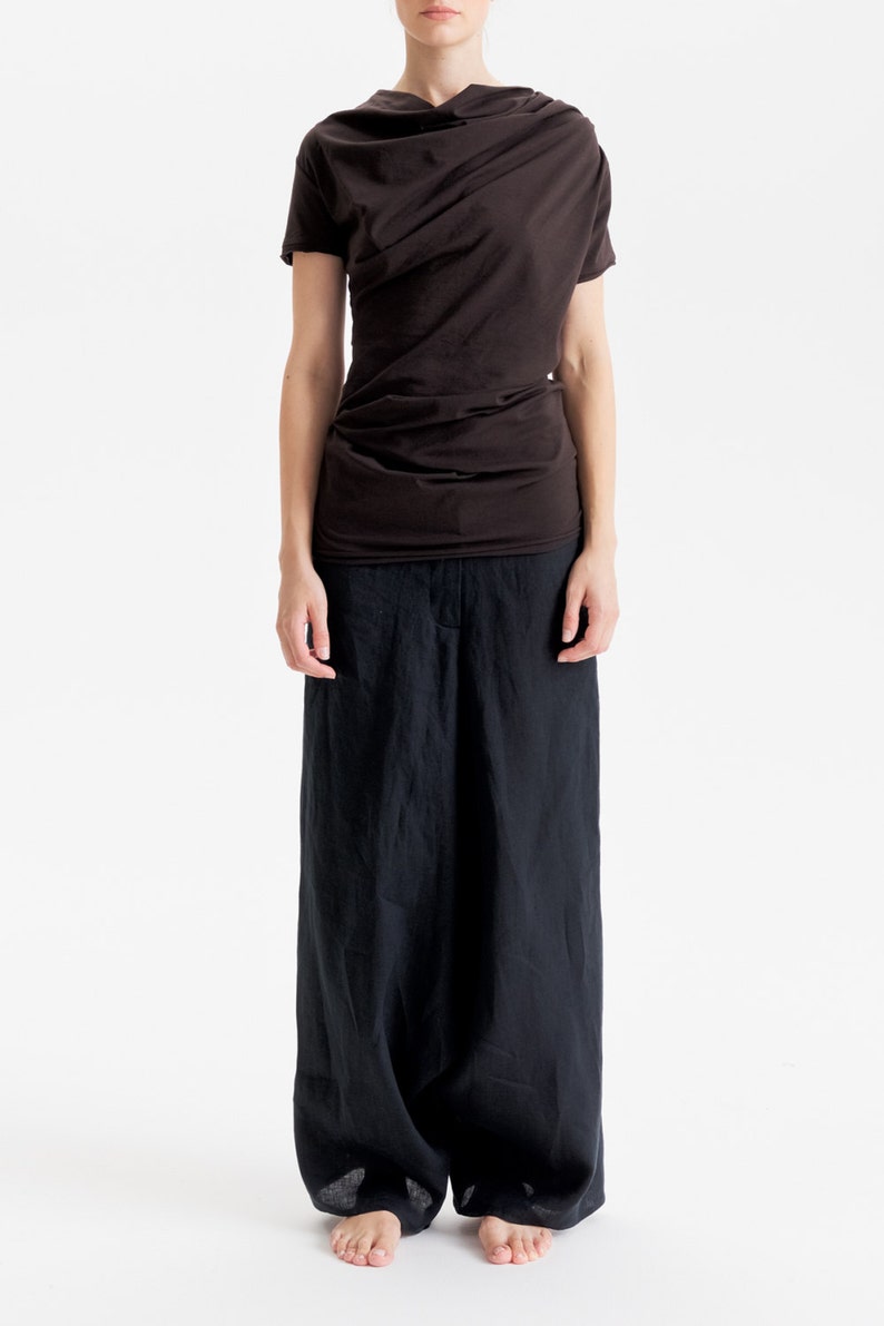 May include: A brown draped top with short sleeves and a pair of black wide-leg pants.