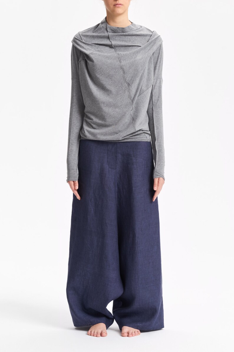 May include: A gray long-sleeved shirt with a draped neckline and a blue linen pair of wide-leg pants.