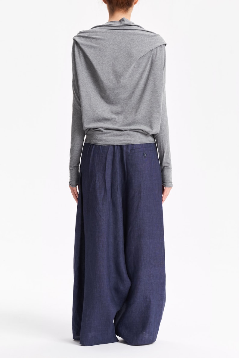 May include: A gray long-sleeved top with a cowl neck and a pair of dark blue wide-leg pants.