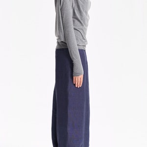 May include: A gray long-sleeved shirt with a cowl neck and a pair of dark blue wide-leg pants.