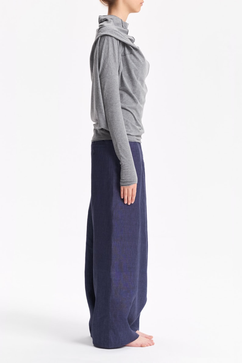 May include: A gray long-sleeved shirt with a cowl neck and a pair of dark blue wide-leg pants.