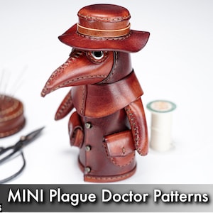 May include: A brown leather plague doctor figurine featuring a wide-brimmed hat, a long beak mask, and a coat with small pockets. The item is displayed alongside a circular leather pincushion with needles, black metal scissors, and a spool of white thread.