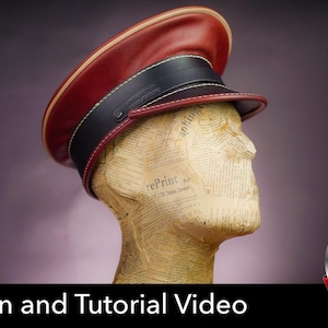 Pode incluir: Um boné estruturado com uma coroa vermelho-escura e uma faixa de couro preta na frente. O boné é exibido em uma cabeça de manequim coberta com papel de jornal. O texto "Pattern and Tutorial Video" aparece na parte inferior da imagem.
