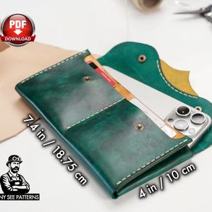 May include: A handcrafted, green leather phone case with white stitching. The case, measuring 7.4 inches by 4 inches, features a snap closure and holds a smartphone and cards. The design includes a unique flap and the text "TONY SEE PATTERNS".