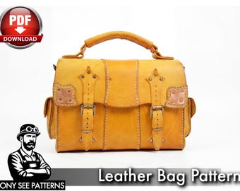 May include: A tan leather satchel featuring a top handle, two front straps with brass-toned buckles, and decorative metal corner accents. The bag has a structured rectangular body with side pockets and visible stitching throughout the exterior surface.