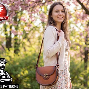 May include: A brown leather crossbody bag with a curved bottom and a decorative clasp. The bag has a long strap and is worn over the shoulder. The image also includes a logo with the text "PDF DOWNLOAD" and "TONY SEE PATTERNS".
