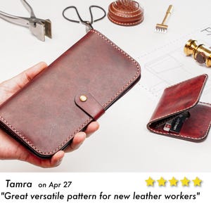 May include: A dark red leather long wallet with a brass snap closure and white stitching, accompanied by a smaller matching leather card holder. The items are displayed alongside leatherworking tools including pliers, scissors, and a brass hammer.