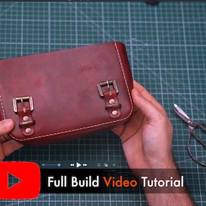 May include: A burgundy leather satchel with brass buckles and white stitching. The bag is rectangular with rounded corners. The text "Full Build Video Tutorial" is displayed on the bottom of the image.
