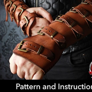 May include: A pair of brown leather arm bracers featuring multiple adjustable straps with antique brass-toned metal buckles. The bracers cover the forearms and wrists, secured by several horizontal straps. Includes a PDF download pattern file.