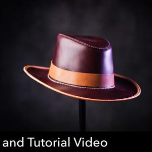 May include: A deep burgundy leather fedora hat featuring a smooth finish, a structured crown, and a wide brim with light tan leather trim. A matching tan leather band encircles the base of the crown. The text PDF DOWNLOAD is visible.
