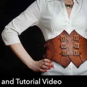 May include: A wide brown leather corset belt featuring a pointed, multi-panel design with three sets of brass-toned metal buckles and straps across the front. The belt is worn over a white button-down shirt, showcasing detailed stitching and rivets.