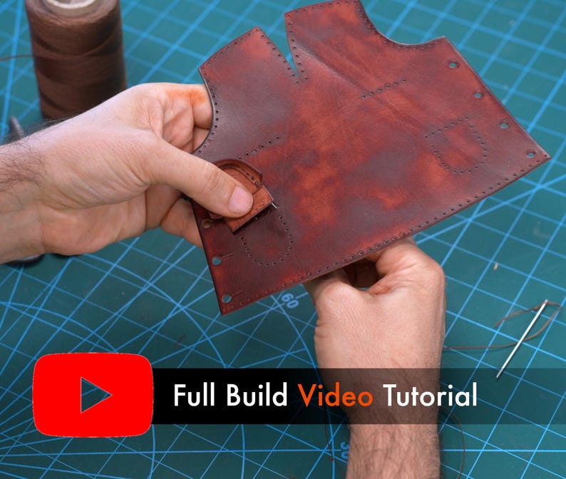 May include: A dark red leather piece with pre-punched stitching holes and a small attached leather tab. The text "Full Build Video Tutorial" is displayed in white and orange next to a red YouTube play icon on the screen.