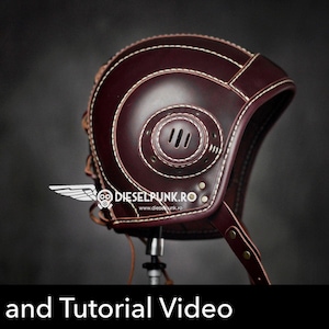 Puede incluir: Un casco de aviador de cuero marrón oscuro con costuras blancas en contraste, un panel lateral circular con tres ranuras de ventilación verticales y una correa para la barbilla. El texto DIESELPUNK.RO y Pattern and Tutorial Video son visibles.
