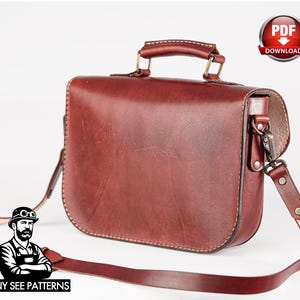 May include: A reddish-brown leather satchel with a top handle and a long, adjustable shoulder strap. The bag has a rectangular shape with rounded edges and a metal clasp. The image includes a "PDF Download" badge and the text "TONY SEE PATTERNS".