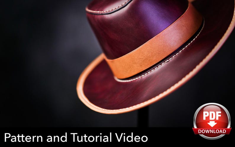 May include: A deep burgundy leather hat featuring a wide tan leather band around the crown and tan leather trim along the edge of the brim. The hat is accented with visible white stitching. Text at the bottom reads Pattern and Tutorial Video.