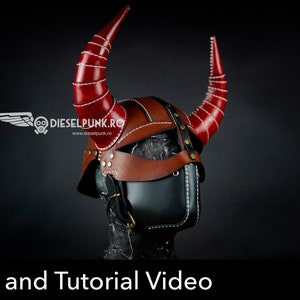 May include: A leather helmet with red horns and a black face mask. The helmet has a brown leather strap and white stitching. The helmet is on a black background. Pattern and Tutorial Video. PDF Download.