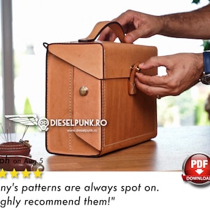 May include: A brown leather briefcase with a metal clasp and a handle. The briefcase is sitting on a wooden table. The text "DIESELPUNK.RO" and "www.dieselpunk.ro" is printed on the briefcase.
