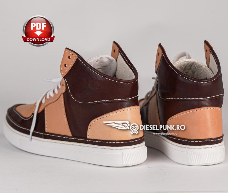Puede incluir: Un par de zapatillas de cuero marr&oacute;n y beige de ca&ntilde;a alta con suela blanca. Las zapatillas tienen un dise&ntilde;o de ala en el lateral y el texto "dieselpunk.ro" y "www.dieselpunk.ro" en el lateral.