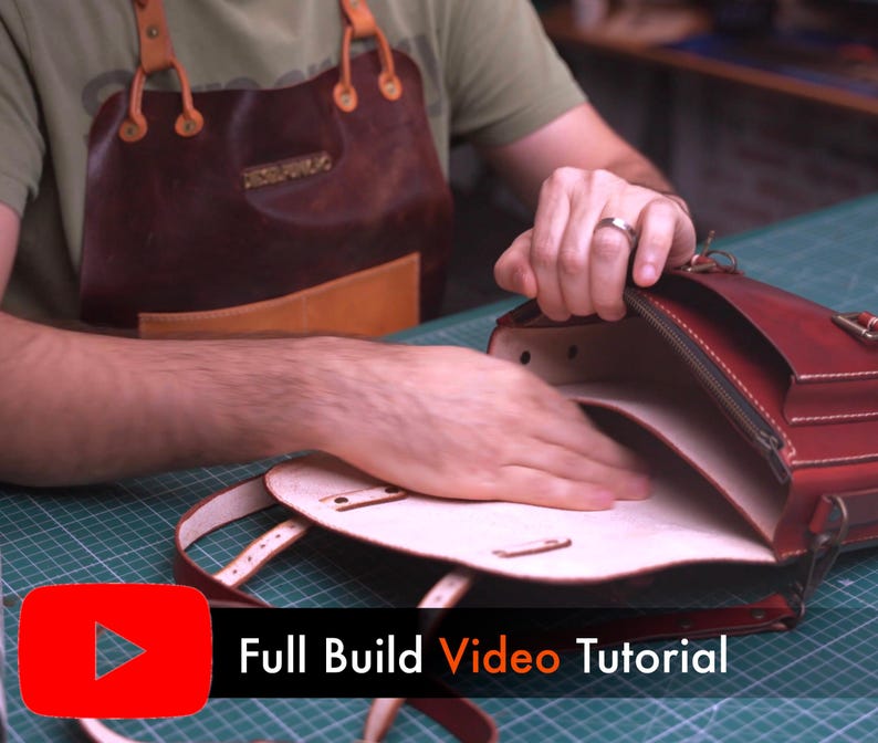 May include: A person is shown working on a red leather satchel. The bag has a flap closure, a zipper, and a shoulder strap. The text "Full Build Video Tutorial" is displayed on the bottom of the image.