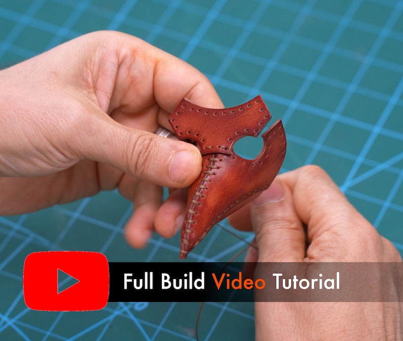 May include: A brown leather plague doctor mask component featuring visible stitching along the center seam and eye openings. The text "Full Build Video Tutorial" is displayed in a red and black rectangular graphic overlay.