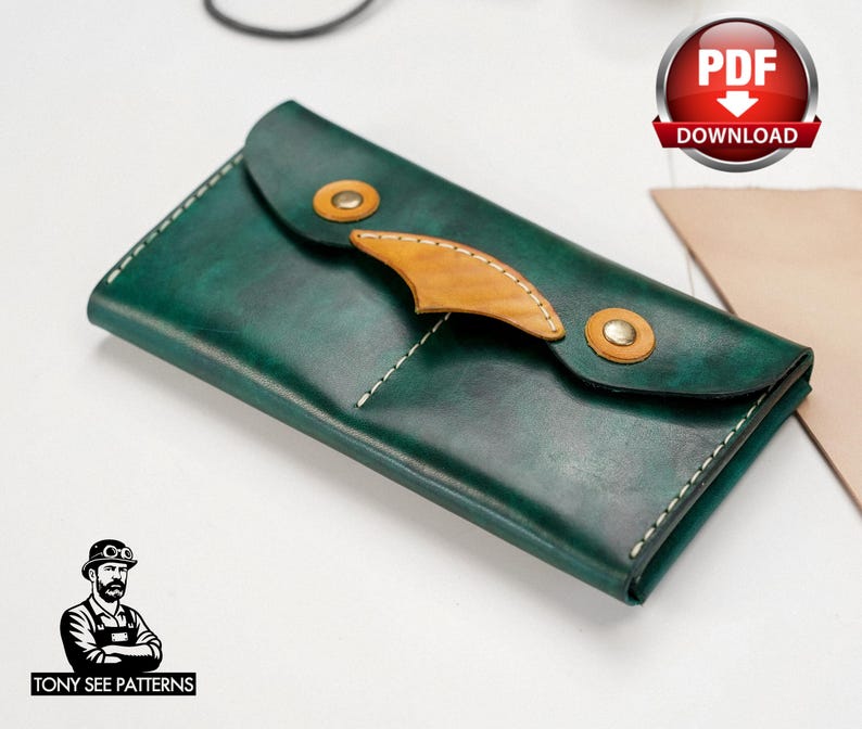 May include: A handcrafted, dark green leather wallet with a unique design. The wallet features a flap closure with two brass-colored rivets and a tan leather accent. White stitching outlines the edges. The wallet is a PDF download.