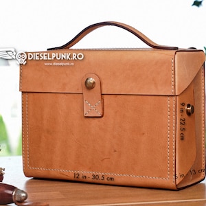 May include: A brown leather briefcase with a top handle, measuring 30.5 cm by 22.5 cm by 13 cm. The briefcase has a brass clasp and stitching details.