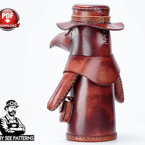 May include: A brown leather plague doctor figurine featuring a wide-brimmed hat, a long beak mask, and a small pouch attached to the side. The figure is constructed with visible stitching along the edges and has a smooth, polished finish.