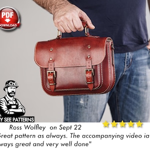 May include: A reddish-brown leather satchel with a top handle and two front buckles. The bag is held by a person wearing blue jeans and a navy blue shirt. The image includes the text "PDF DOWNLOAD" and a customer review.