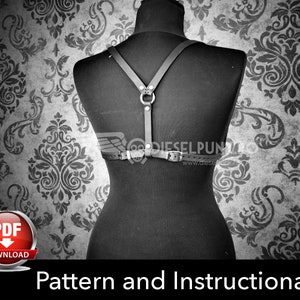 Może przedstawiać: Czarny sk&oacute;rzany uprząż z paskami i metalowym pierścieniem. Uprząż jest prezentowana na manekinie na tle wzorzystego tła. Tekst "Pattern and Instructional Video" znajduje się na dole obrazu. Przycisk pobierania PDF znajduje się w lewym dolnym rogu.