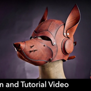 May include: A brown leather dog mask featuring pointed ears, metallic studs on the snout, and visible stitching along the panels. The mask is displayed on a mannequin head. Text at the bottom reads: Pattern and Tutorial Video with a PDF icon.