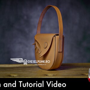 May include: A brown leather handbag with a flap and a strap. The bag has a unique design with a bird-like shape. The bag is sitting on a wooden surface. The text "Pattern and Tutorial Video" is at the bottom of the image. A red button with the text "PDF DOWNLOAD" is in the lower right corner of the image.